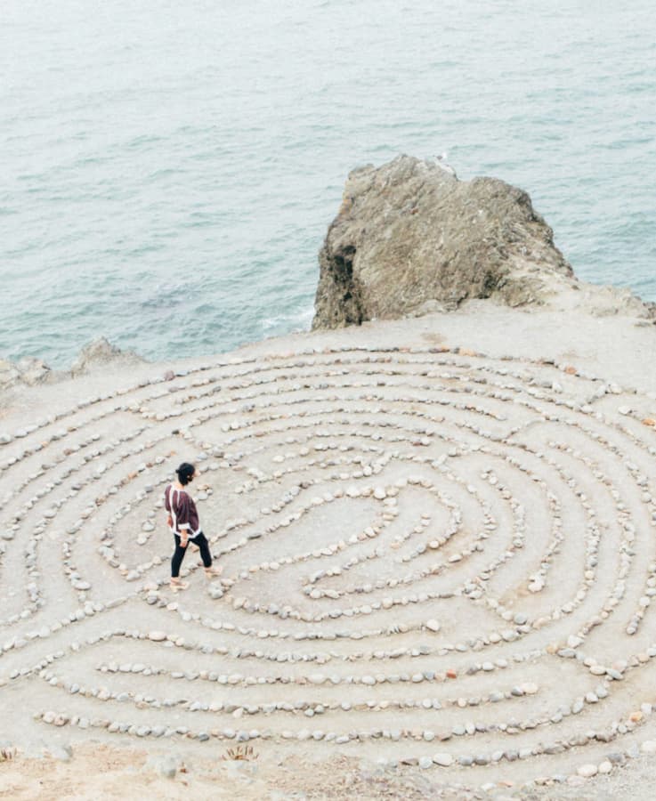 A woman walking through a rock maze