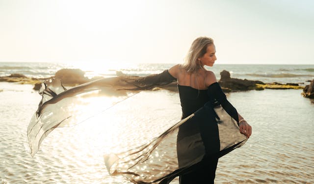 A woman by the sea in a flowing gown